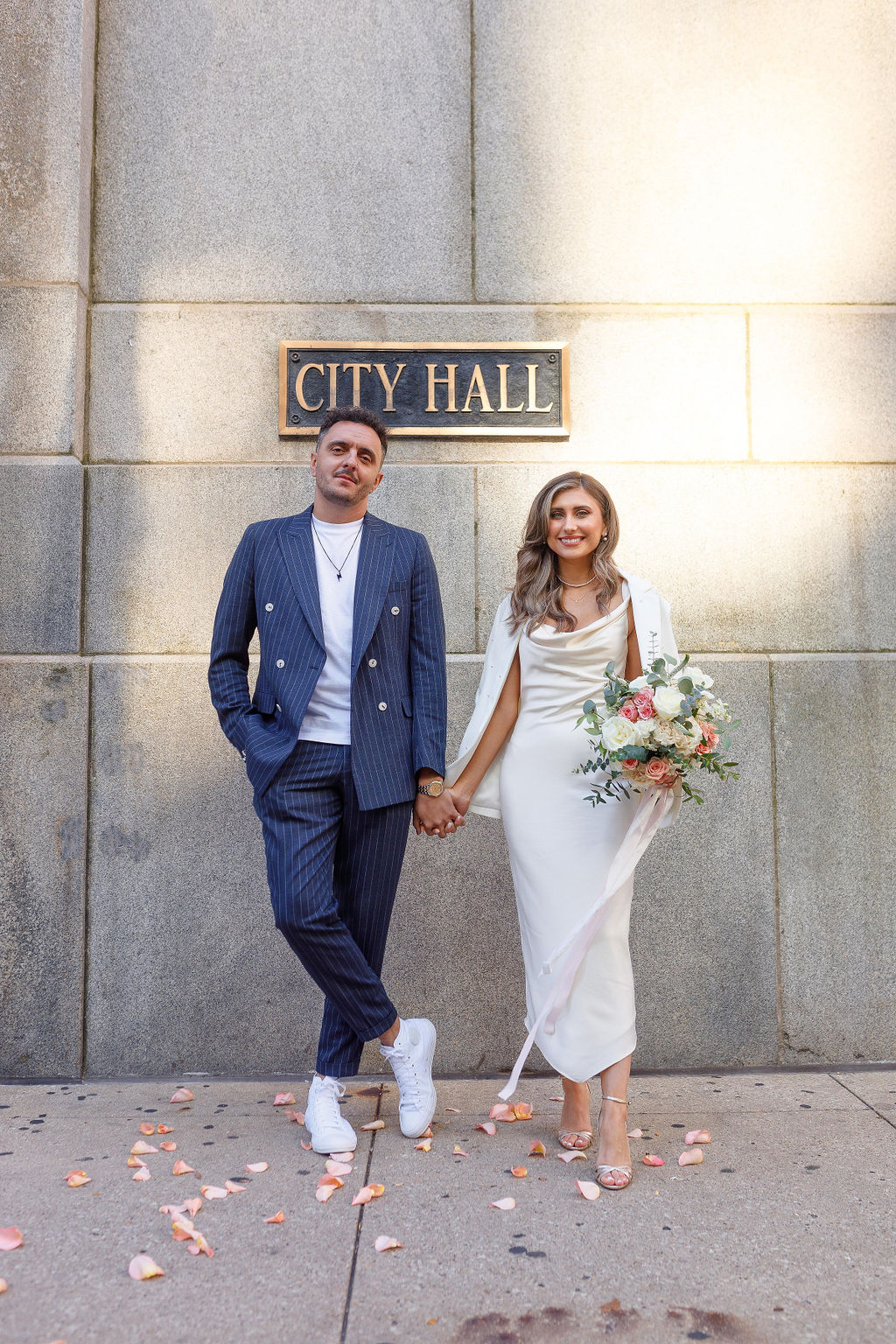 Chicago Couple holding hands outside City Hall Sign after eloping.