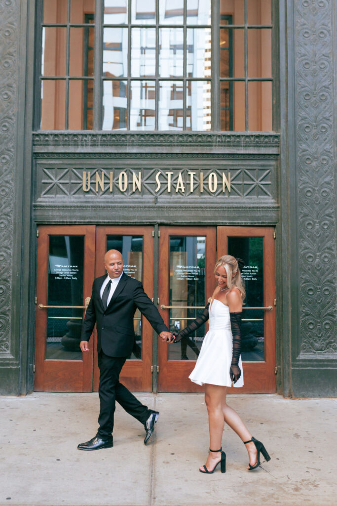 ouple holding hands inside Chicago Union Station with tall windows and sweeping architecture